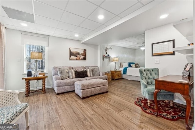 interior space featuring a paneled ceiling and light hardwood / wood-style floors