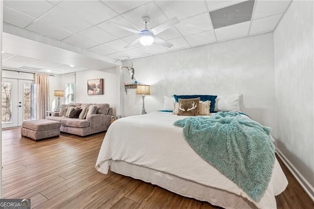 bedroom featuring hardwood / wood-style flooring, a paneled ceiling, french doors, and access to outside