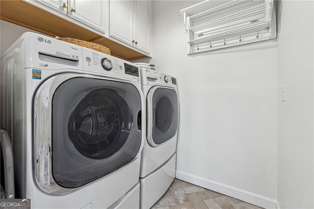 laundry area with separate washer and dryer and cabinets