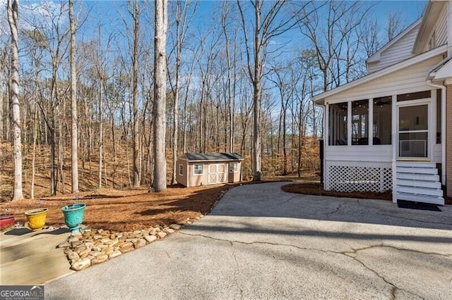 view of yard featuring a storage unit and a sunroom