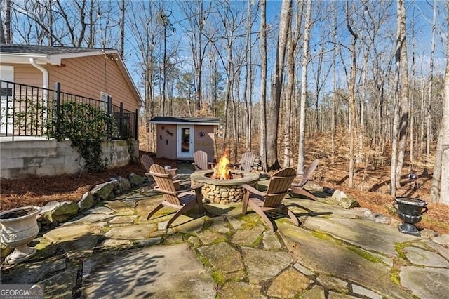 view of patio / terrace with a storage unit and an outdoor fire pit