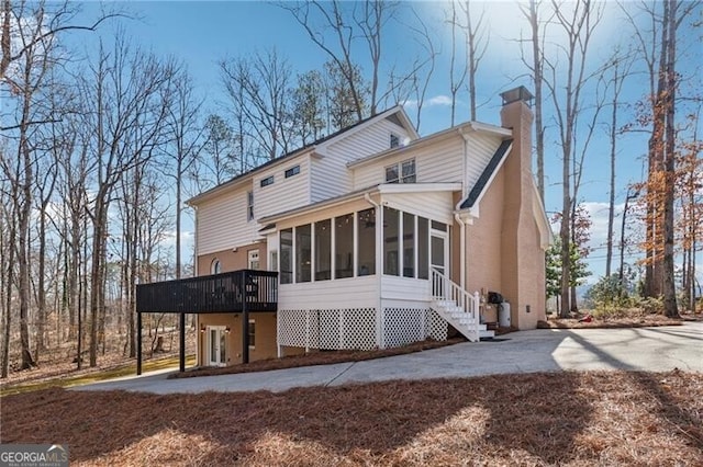 back of house featuring a sunroom and a patio