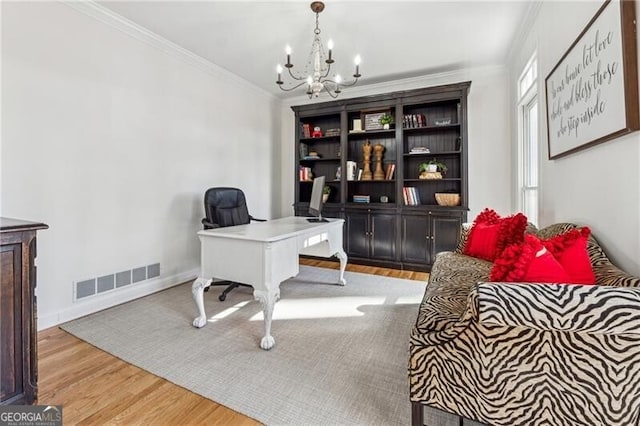 home office featuring a notable chandelier, crown molding, and light wood-type flooring