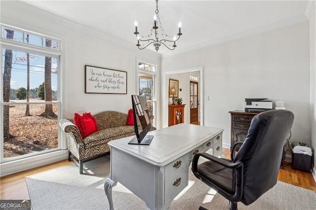 office space featuring an inviting chandelier, ornamental molding, and light hardwood / wood-style floors