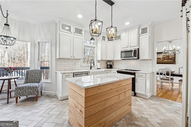 kitchen with appliances with stainless steel finishes, a center island, and white cabinets