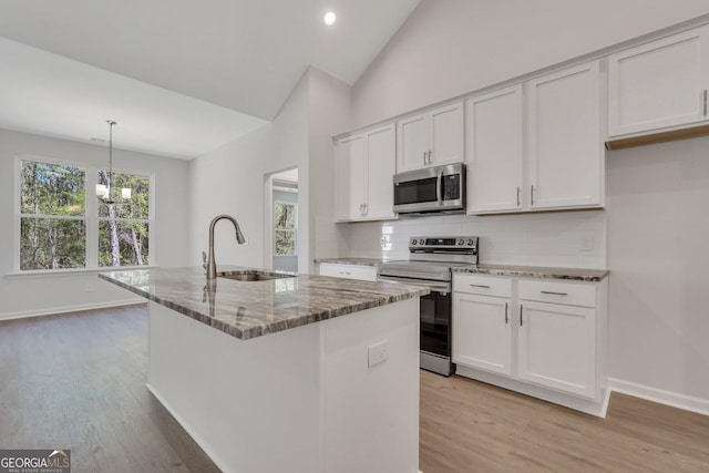 kitchen featuring pendant lighting, sink, a kitchen island with sink, stainless steel appliances, and white cabinets