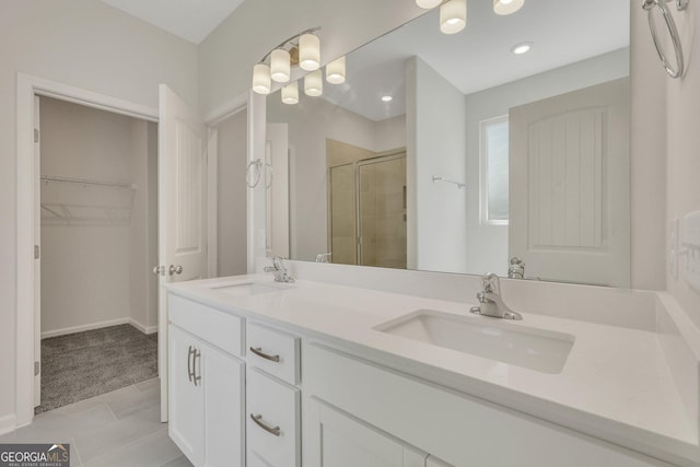 bathroom featuring a shower stall, a walk in closet, double vanity, tile patterned flooring, and recessed lighting