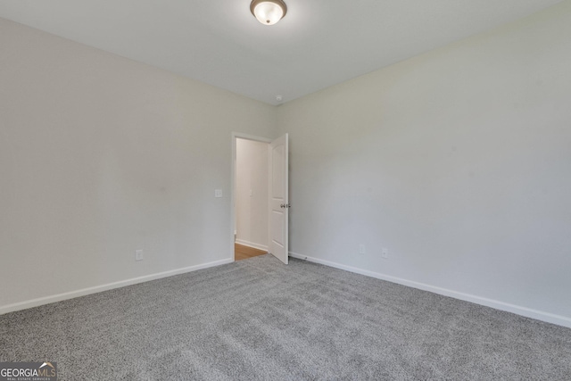 empty room featuring carpet flooring and baseboards