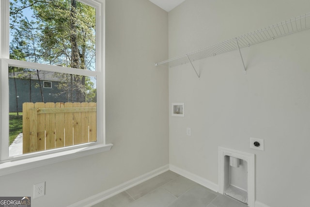 laundry area featuring electric dryer hookup, washer hookup, baseboards, and tile patterned floors