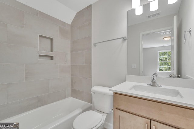 full bathroom with tiled shower / bath, vanity, and toilet