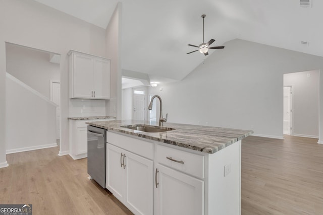 kitchen with sink, white cabinets, stainless steel dishwasher, light stone counters, and a center island with sink