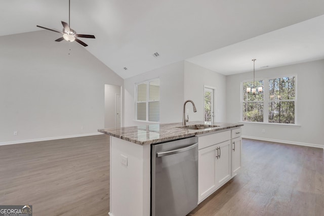 kitchen featuring stainless steel dishwasher, a sink, open floor plan, light wood-style flooring, and high vaulted ceiling