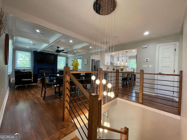 interior space featuring hardwood / wood-style flooring, ceiling fan, coffered ceiling, and beam ceiling