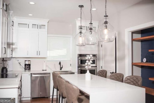 kitchen featuring pendant lighting, sink, white cabinetry, and appliances with stainless steel finishes