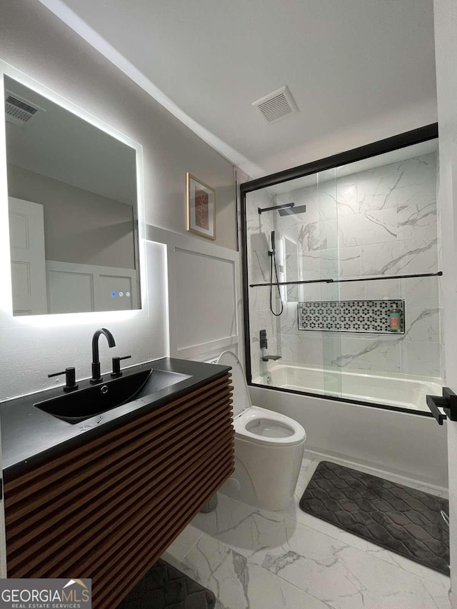 full bathroom featuring vanity, enclosed tub / shower combo, and toilet