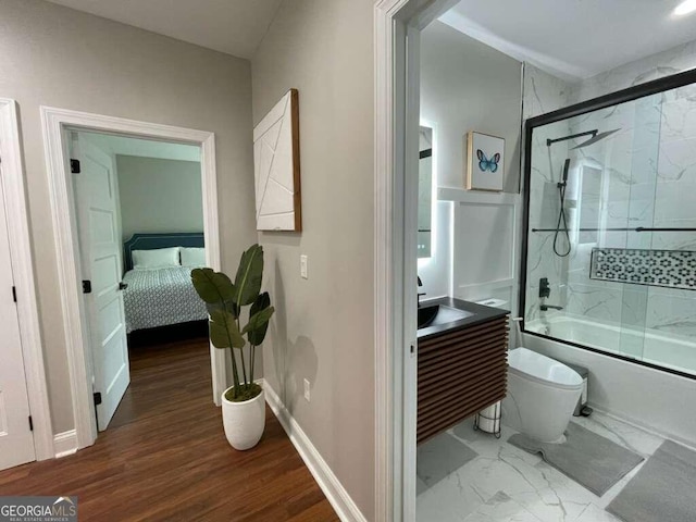 bathroom featuring hardwood / wood-style flooring, toilet, and combined bath / shower with glass door