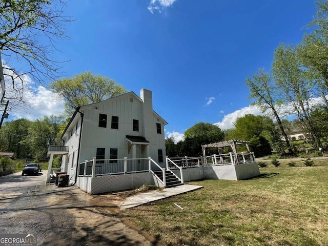 back of house featuring a yard and a pergola