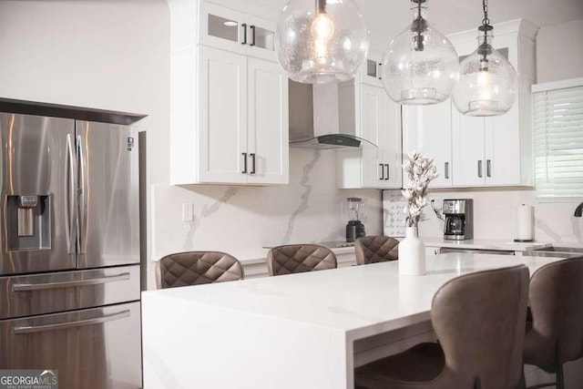 kitchen with white cabinetry, stainless steel fridge with ice dispenser, decorative light fixtures, and a breakfast bar