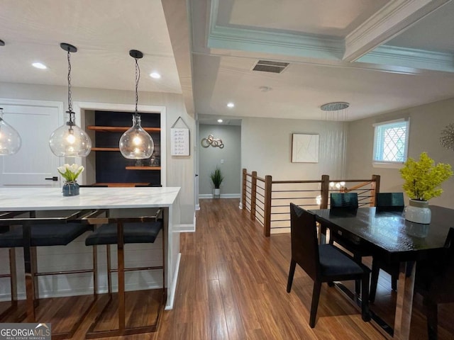 dining space with hardwood / wood-style floors and ornamental molding