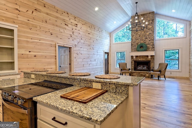 kitchen featuring pendant lighting, black electric range oven, and wood walls