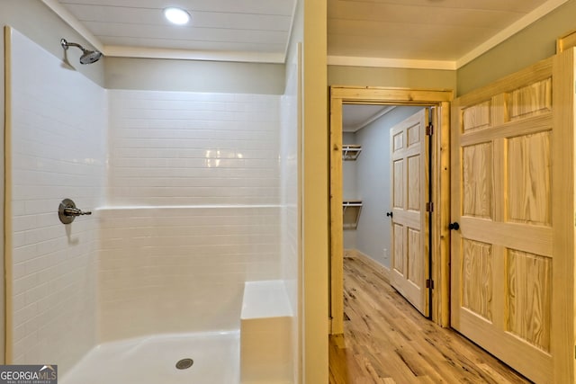 bathroom with wood-type flooring and a tile shower