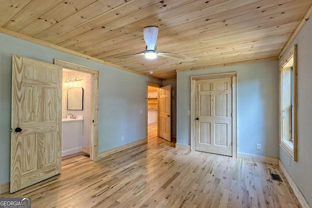 unfurnished bedroom featuring light wood-type flooring, ensuite bath, and wood ceiling