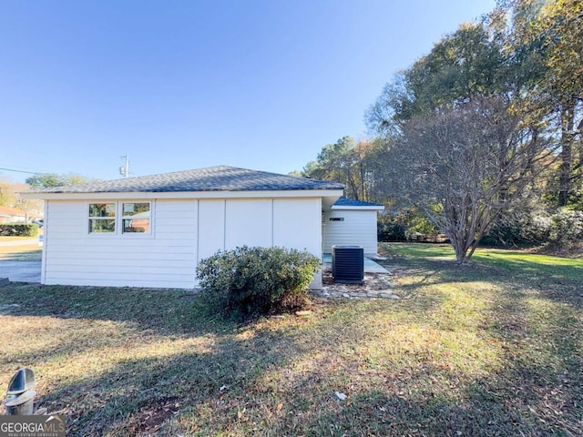 view of side of property with cooling unit and a lawn