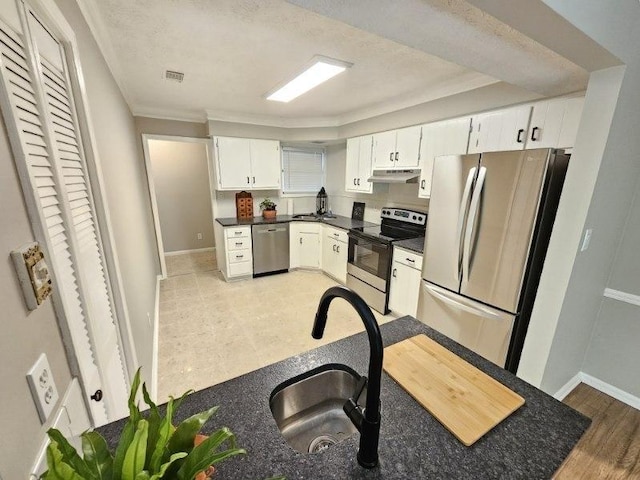 kitchen with sink, white cabinets, stainless steel appliances, crown molding, and light wood-type flooring