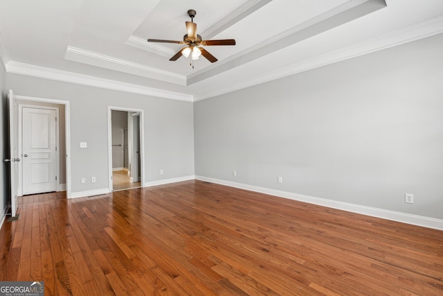 spare room featuring ceiling fan, wood-type flooring, a raised ceiling, and ornamental molding