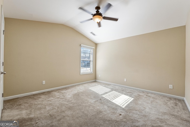 unfurnished room with vaulted ceiling, light colored carpet, and ceiling fan