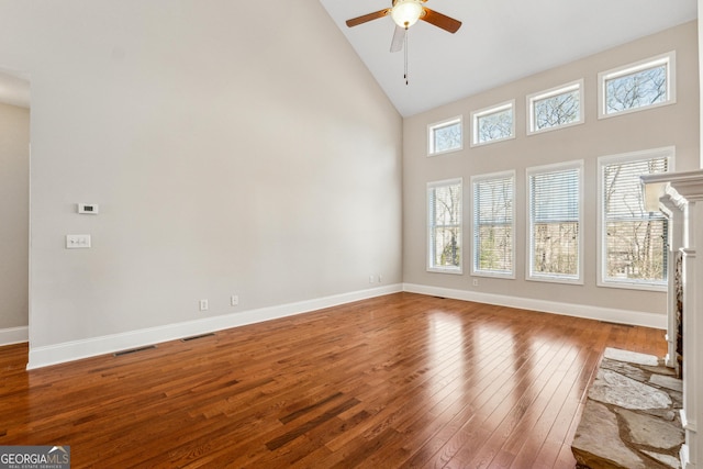 unfurnished living room with hardwood / wood-style flooring, high vaulted ceiling, and ceiling fan