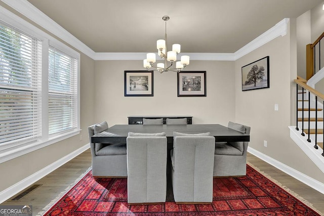 dining room with ornamental molding, a notable chandelier, and dark hardwood / wood-style flooring