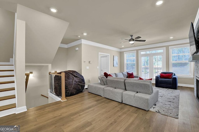 living room featuring ornamental molding, ceiling fan, and light hardwood / wood-style flooring