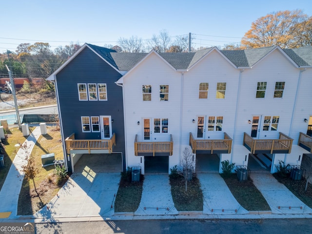 view of front of house featuring a balcony and central AC unit