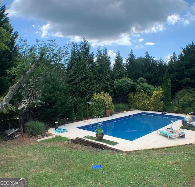 view of swimming pool with a lawn