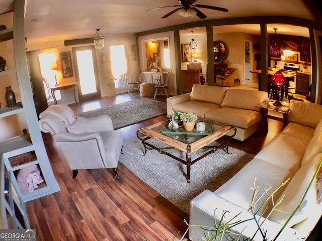 living room with wood-type flooring and ceiling fan with notable chandelier