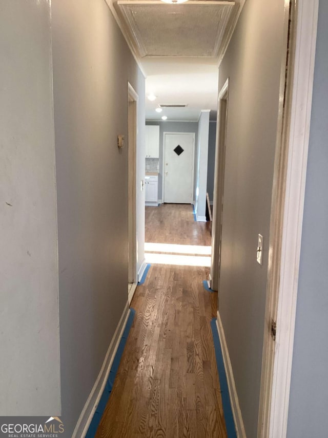 hallway featuring crown molding and wood-type flooring