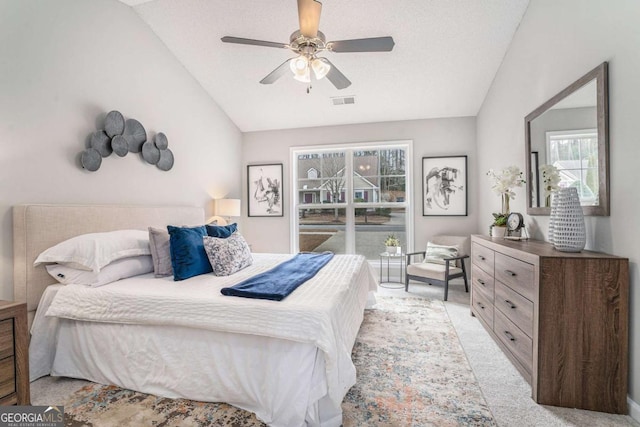 carpeted bedroom featuring a textured ceiling, vaulted ceiling, and ceiling fan