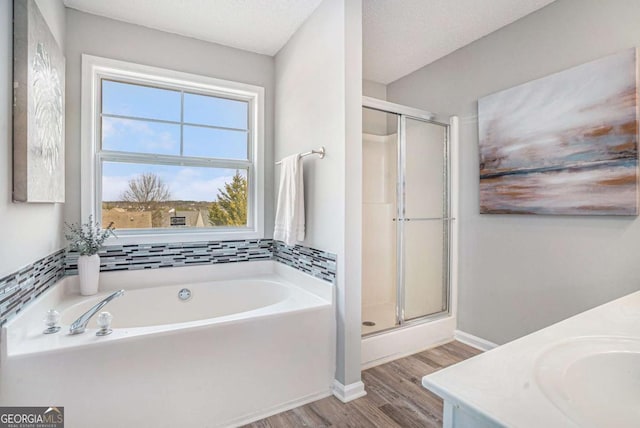 bathroom featuring vanity, hardwood / wood-style flooring, plus walk in shower, and a textured ceiling