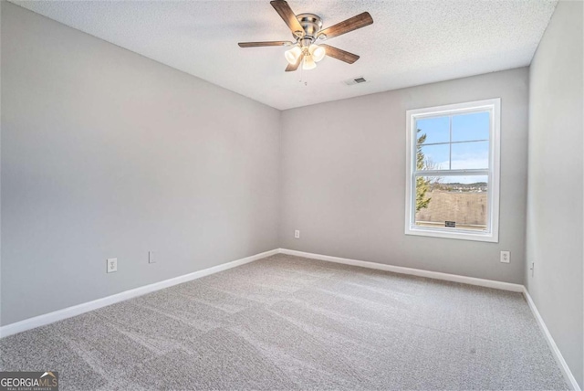 unfurnished room with ceiling fan, carpet, and a textured ceiling