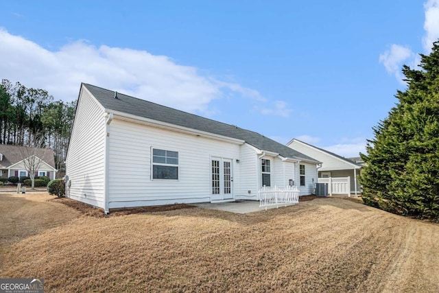 rear view of property with french doors, central AC unit, a patio, and a lawn