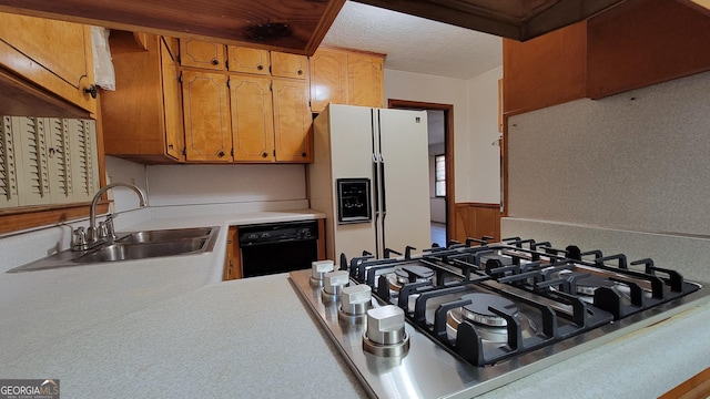 kitchen with sink, a textured ceiling, dishwasher, white fridge with ice dispenser, and stainless steel gas stovetop