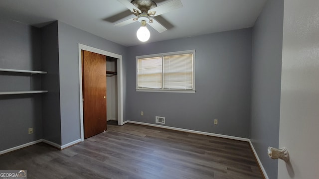 unfurnished bedroom with dark wood-type flooring, ceiling fan, and a closet