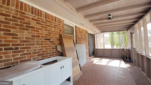 unfurnished sunroom with beam ceiling