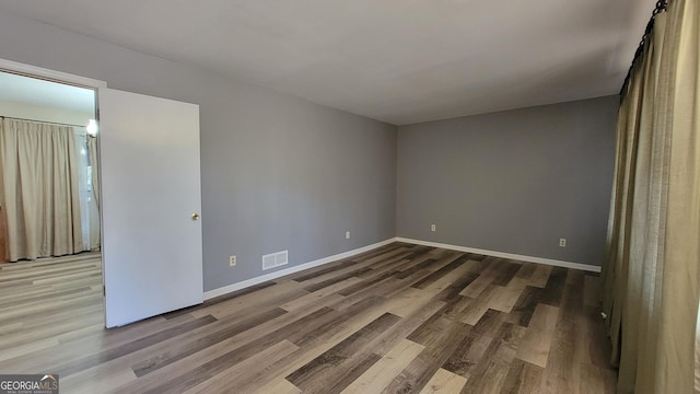 spare room with wood-type flooring