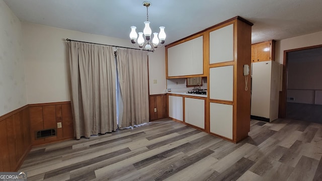 kitchen featuring white cabinetry, an inviting chandelier, light hardwood / wood-style floors, and decorative light fixtures