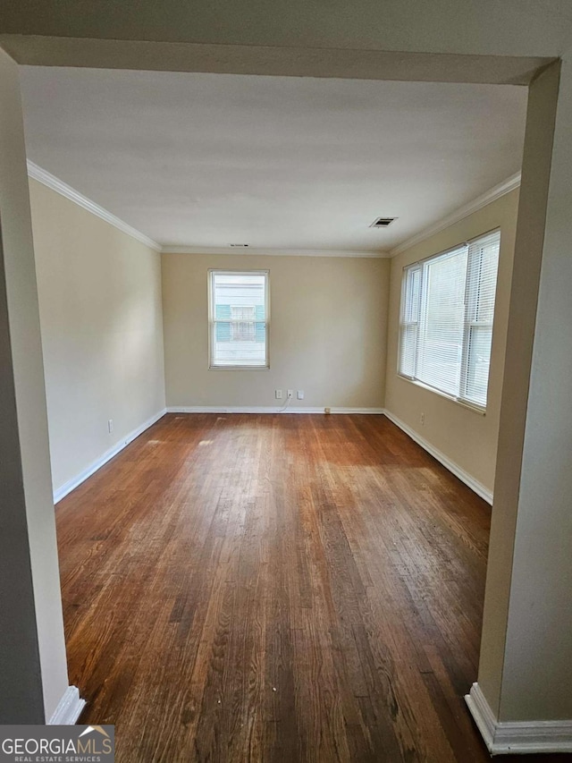 spare room featuring ornamental molding and dark hardwood / wood-style floors