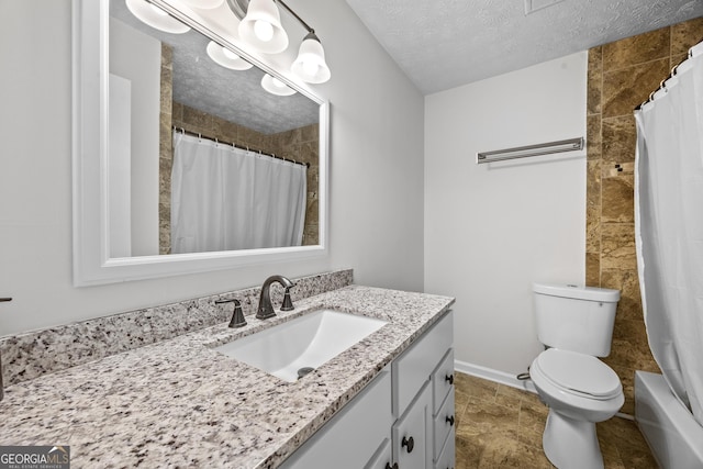 bathroom with vanity, toilet, and a textured ceiling