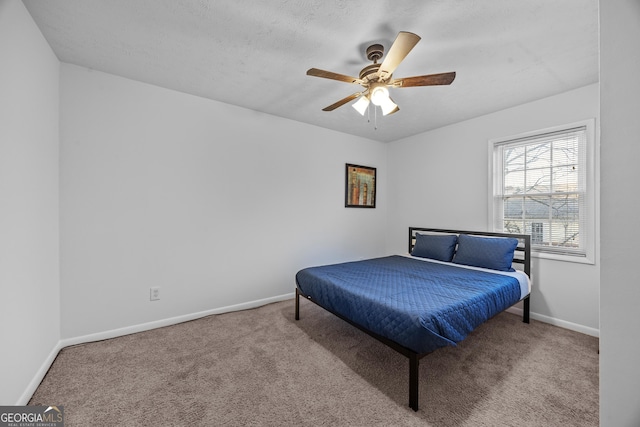 bedroom with ceiling fan, light carpet, and a textured ceiling