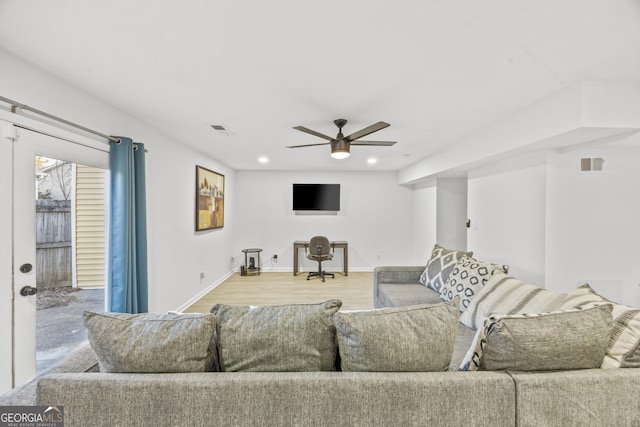 living room with ceiling fan and light wood-type flooring